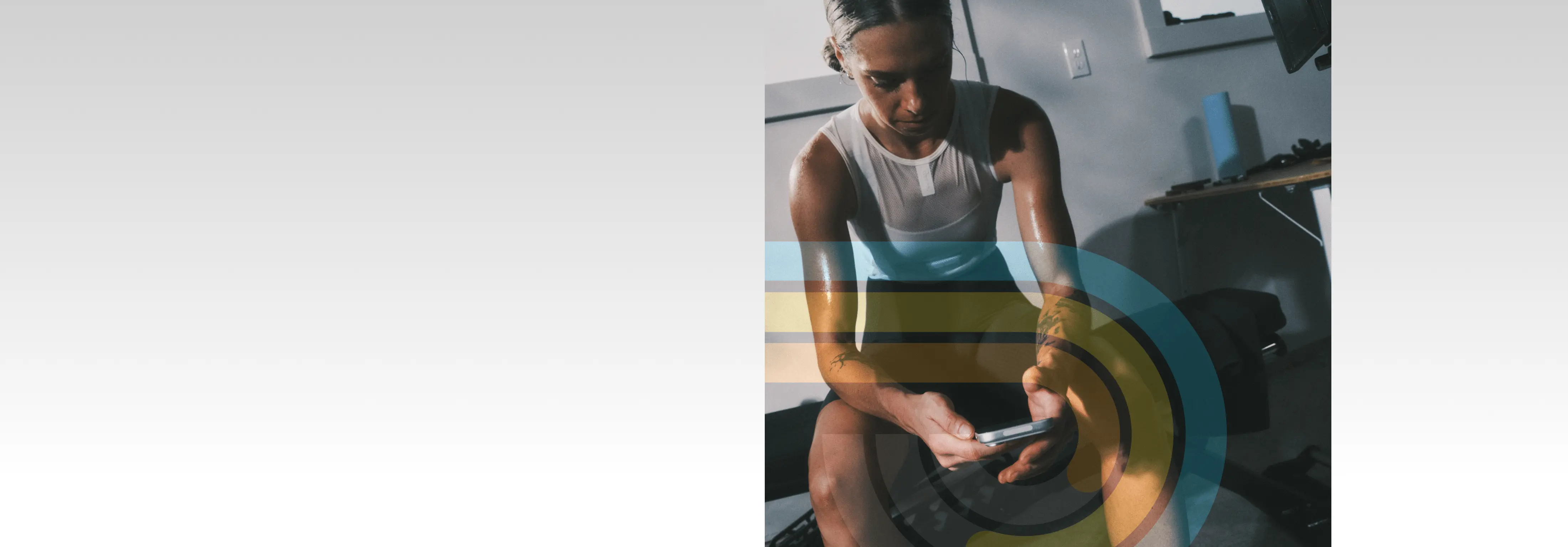 Athlete checking her training data on her phone after a 
  workout in a home gym