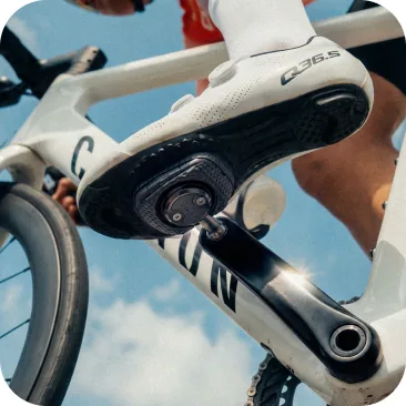 Road cyclist in motion, illustrating optimal leg extension and biomechanical fit provided by the pedals